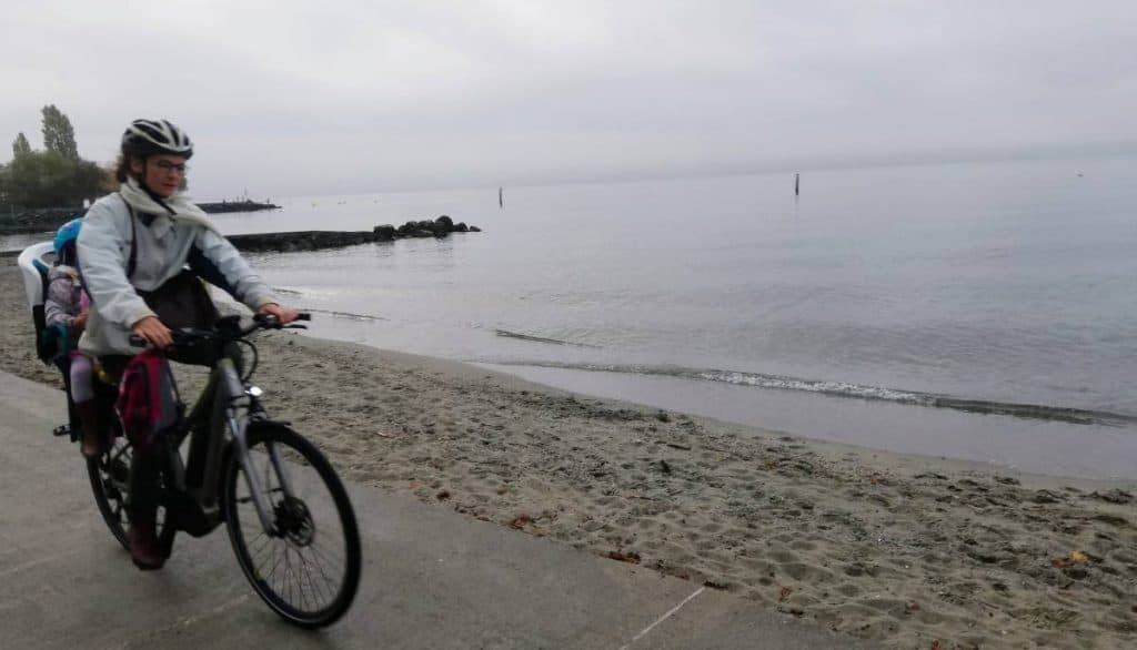 Easy E-Biking - woman e-biking lake coast, helping to make electric biking practical and fun